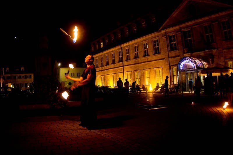 Detlef Vogt jongliert bei einer Feuershow in Bamberg mit brennenden Fackeln