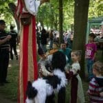 Gaukler auf Stelzen , Kinder streicheln Hundemarionette