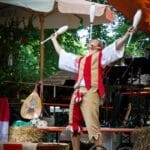 Gaukler zeigt Keulenjonglage auf der Bühne