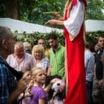 Gaukler auf Stelzen mit Zuschauern