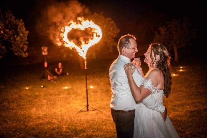 Paar tanzt während der Hochzeitsfeuershow vor dem Feuerherz