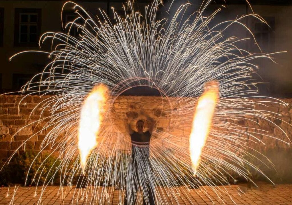 Feuerkünstler, der eine Feuershow zur Firmenfeier mit Funkenpoi durchführt