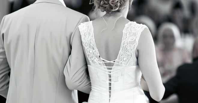 Ein Brautpaar schreitet den Gang entlang bei einer unterhaltsamen Hochzeit.