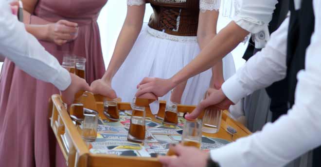 Eine Gruppe von Menschen, die an einem Hochzeitsunterhaltungsprogramm teilnehmen und Bier Pong spielen.