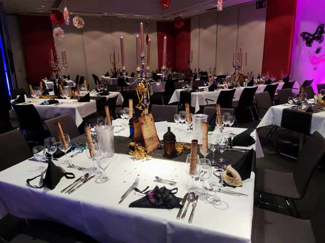 Ein Raum mit Tischen und Stühlen für eine Silvester Gala.