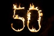 Die brennende Zahl 50, die hell vor schwarzem Hintergrund brennt - Abschluss der Feuershow zum Geburtstag des Feuerkünstlers.