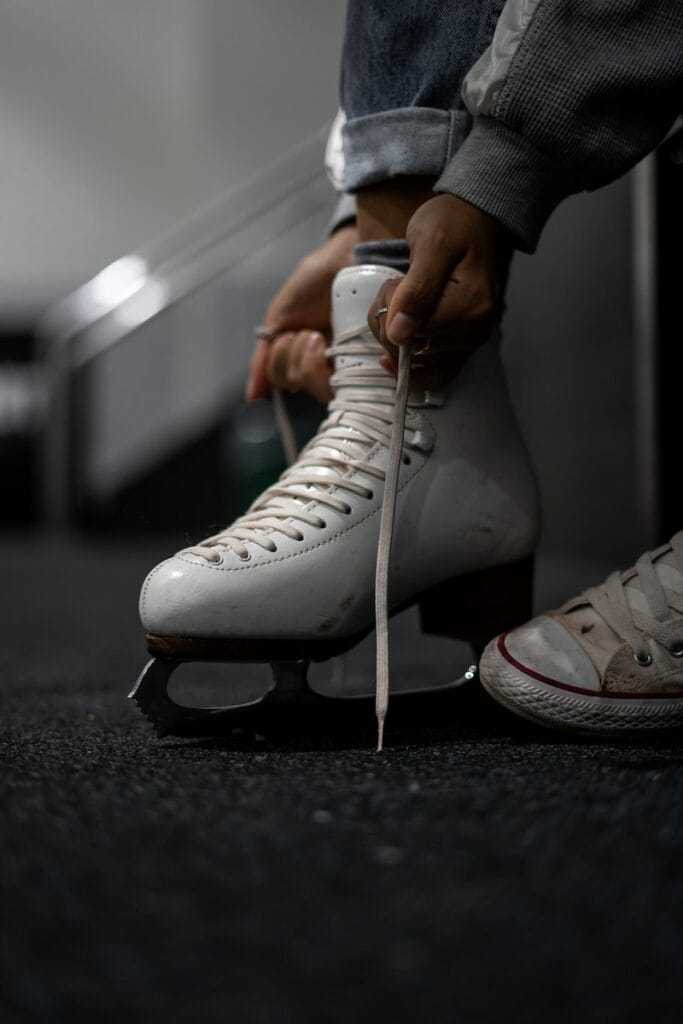 Eine Person zieht einen Schlittschuh an